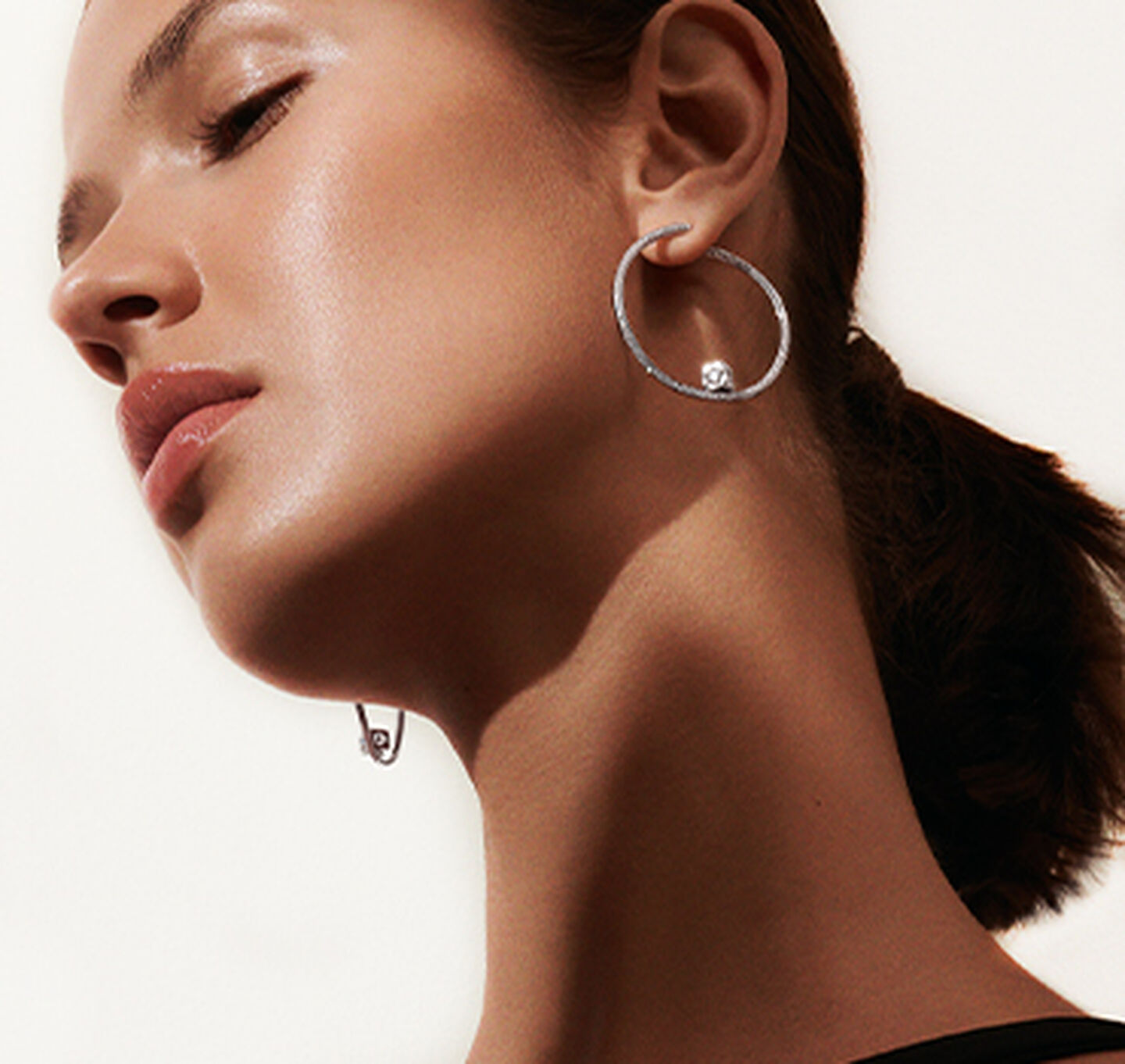 A woman wearing Le Cube Diamant earrings by dinh van.